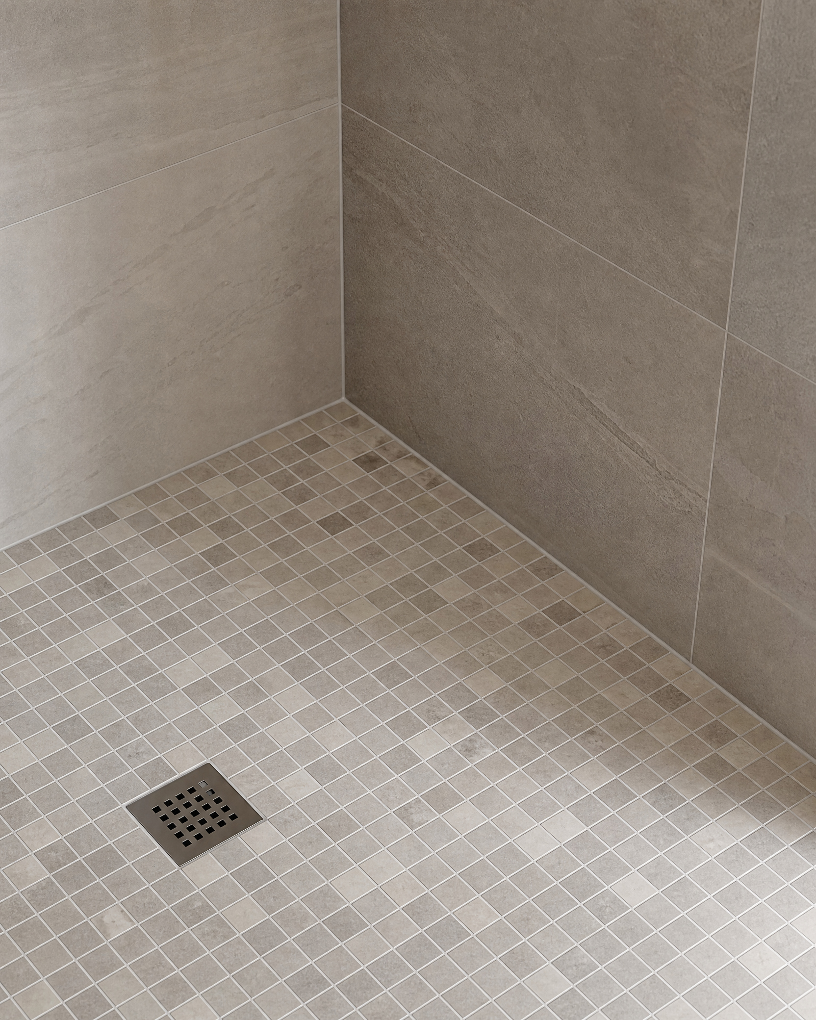 Mosaic shower floor tile and porcelain wall tile finishing detail